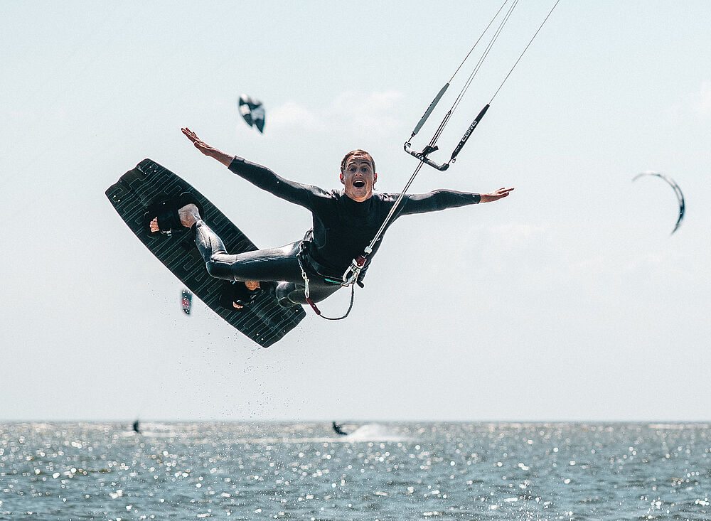 Kitesurf Holland004 beim spektakulären Kiteboarding-Sprung über dem Meer - Kitesurfen Wassersport Abenteuer