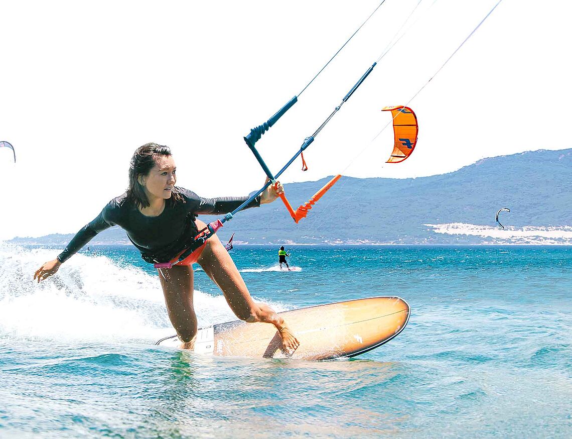 KBC Tarifa Kiteschule: Kitesurferin beim Kiteboarding auf türkisblauem Wasser mit Kite, professioneller Wassersport Unterrich
