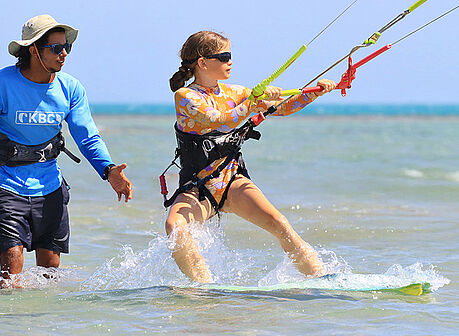 Kitesurf Kinder-Kurs an der Kiteschule KBC El Gouna für Kids - Instruktor unterrichtet junge Kitesurferin im flachen Wasser der Lagune vom Roten Meer