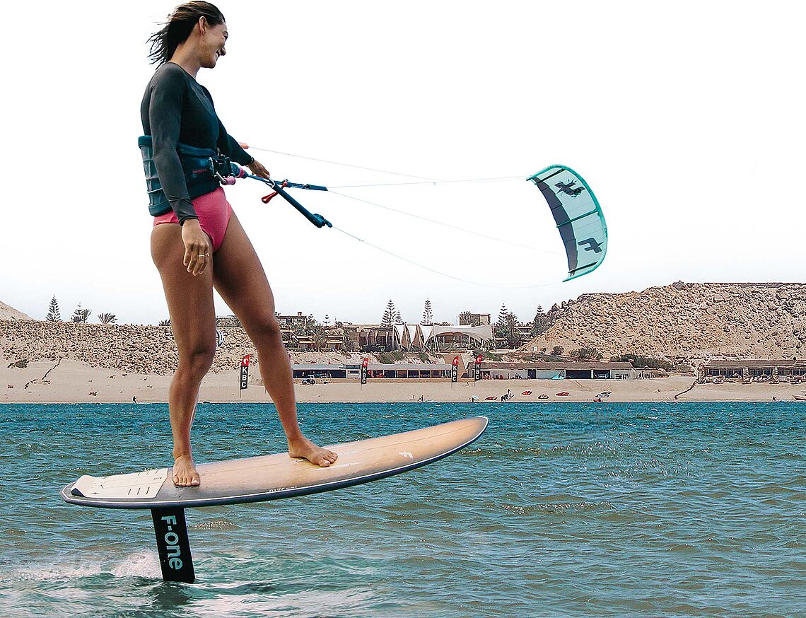 Escuela de kitesurf Dakhla Lagoon KBC - F-ONE Kitesurfer en foilboard con cometa mientras practica kiteboarding en la laguna 