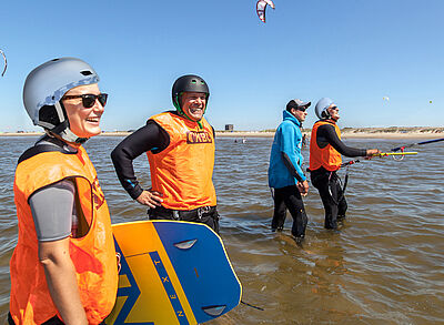 Groep kite-studenten Kitecamp in wetsuit op de Noordzee