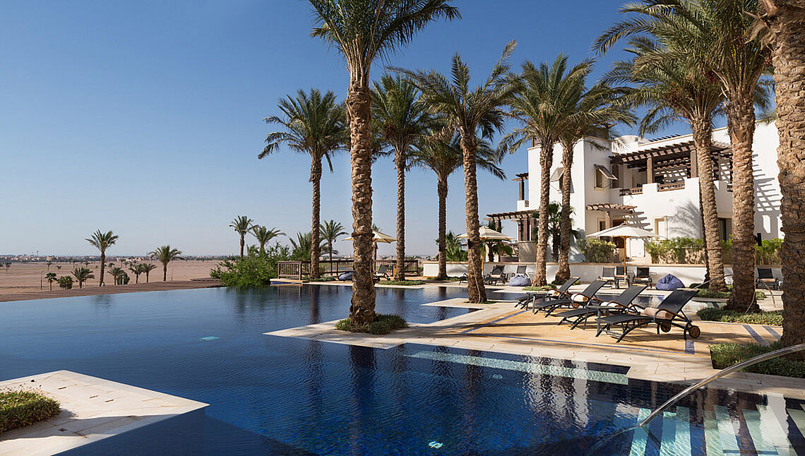Luxury pool with palm trees at Kiteboarding Club KBC El Gouna - perfect relaxation spot after kitesurfing sessions