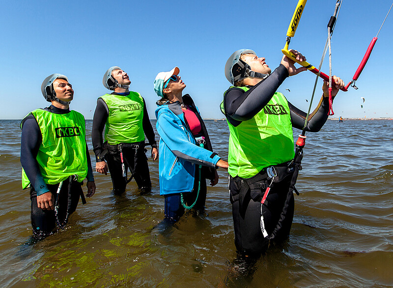 Group of kite students standing in wetsuits in the North Sea