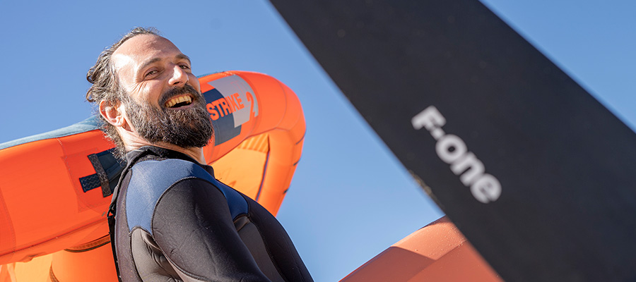 Wingfoilschool kiteboarding instructor at Kiteboarding Club KBC Dakhla with kite and wetsuit on Morocco beach