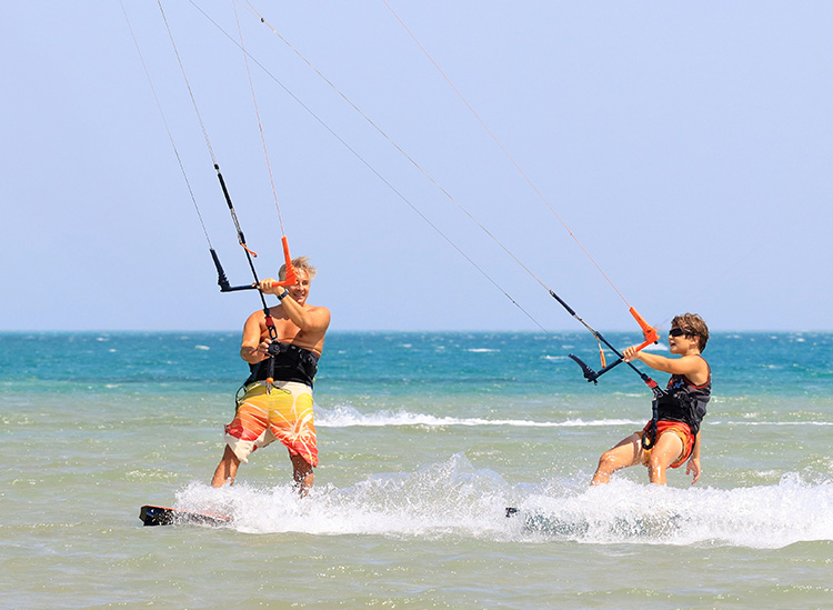 Kinder-Kitesurfen in El Gouna: zwei junge Kitesurfer mit Kites im seichten Wasser beim KBC World Kitesurfing Kurs