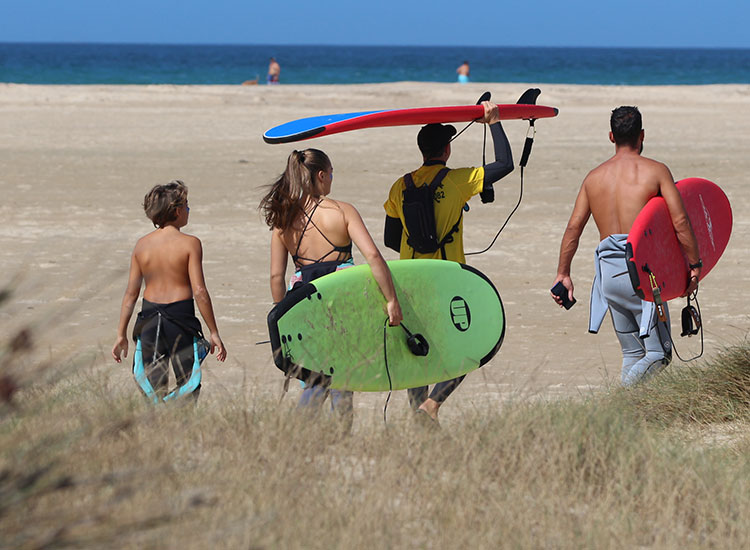 Surfverleih and surfers carrying kiteboards on beach at Kiteboarding Club KBC Tarifa - water sports in Spain