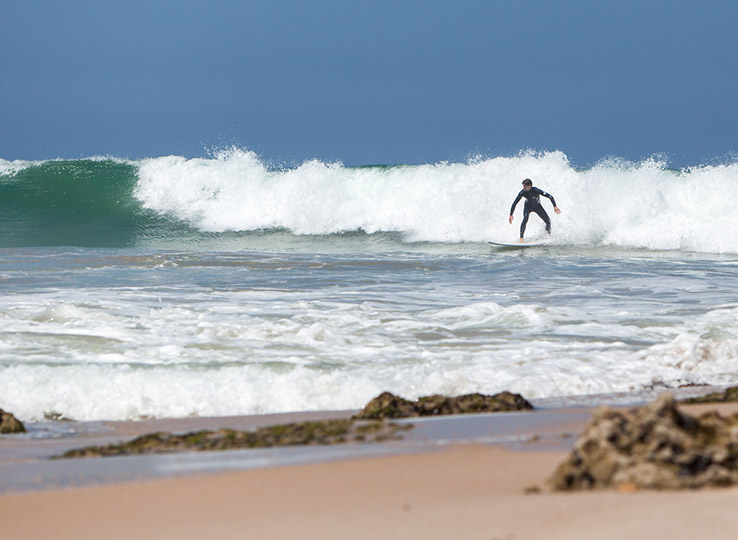 Kitesurfista Wavespot sulle onde in spiaggia sabbiosa - destinazione viaggio sport acquatici kitesurf