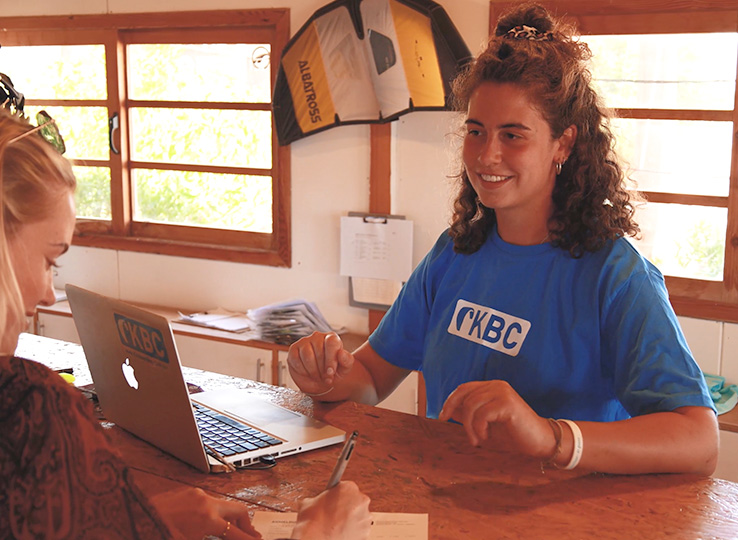 Profil and Rezeption at laptop in kitesurfing station - consulting for kiteboarding courses and travel destinations