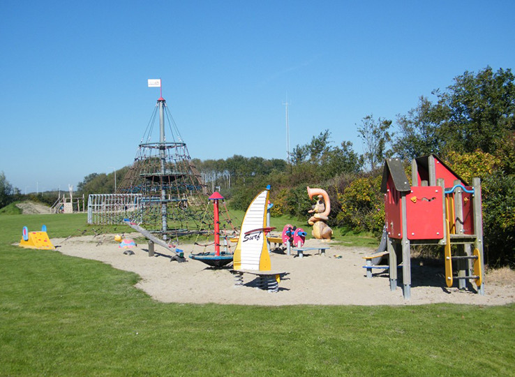 Beach playground with climbing frame and slides - perfect family destination for kiteboarding holidays at coastal resort