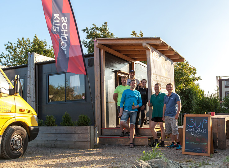 Kitesurfing crew at mobile kiteboarding shop with food truck at beach - perfect stop for kite gear and refreshments
