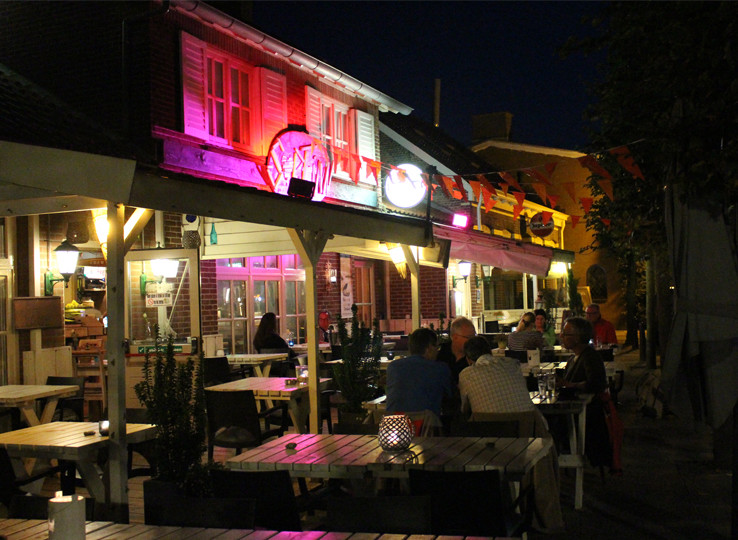 Vibrant beachside restaurant at night with outdoor terrace - perfect spot to unwind after kiteboarding