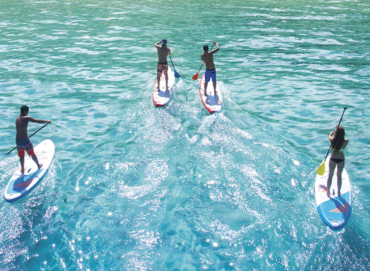 Gruppo di stand-up paddle su acqua turchese - destinazione perfetta per kitesurf e sport acquatici