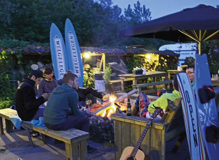 Falò Welgelegen: kitesurfer che si rilassano la sera, kiteboards sullo sfondo, atmosfera accogliente dopo sport acquatici
