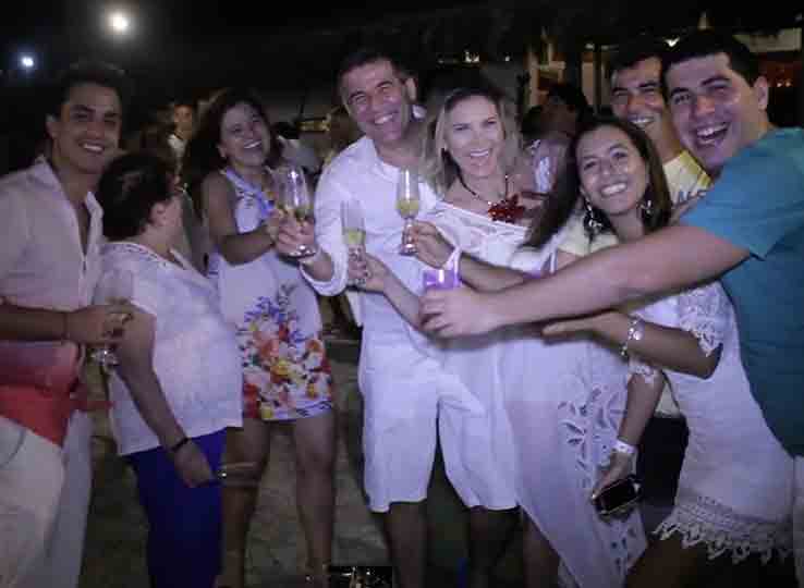 Group of kitesurfers celebrating with drinks at beach destination - perfect evening after kiteboarding water sports session