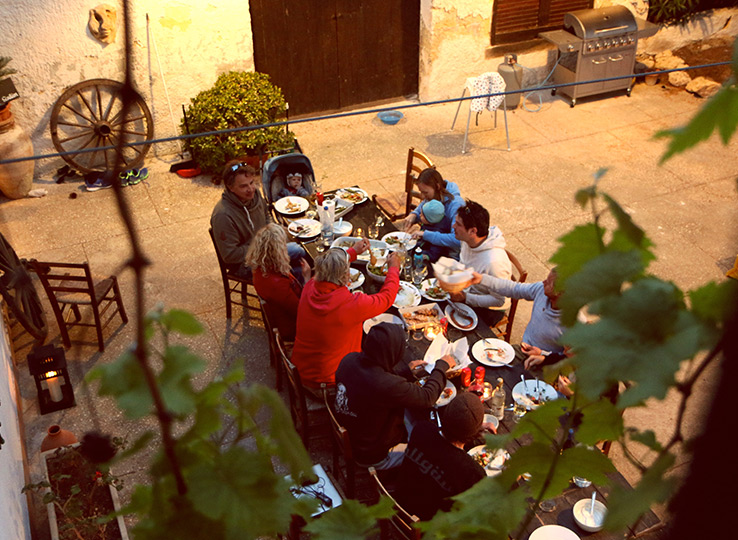 Kitesurfer che si godono pasto all'aperto in terrazza dopo sessione sport acquatici in destinazione viaggio