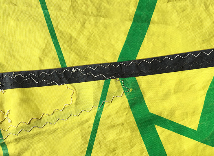 Close-up of yellow-green kitesurfing equipment with black stitching - perfect for beach water sports adventures