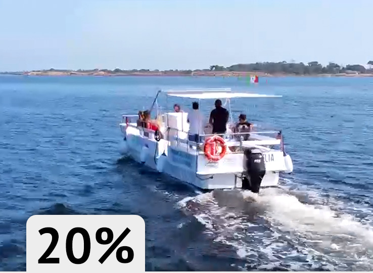 White fishing boat on blue water near coastline - perfect conditions for kiteboarding and water sports