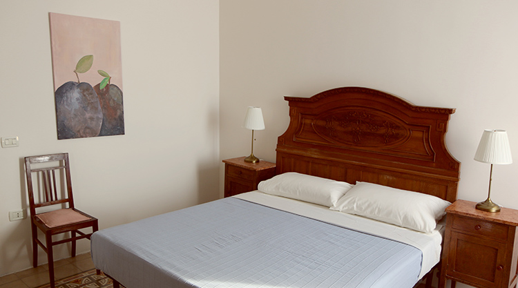 Maestro1 camera d'albergo con letto in legno e comodini - sistemazione comoda per viaggi di kitesurf